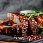 American food concept. Grilled pork ribs with grilled sauce, with smoke, spices and rosemary. Background image. copy space